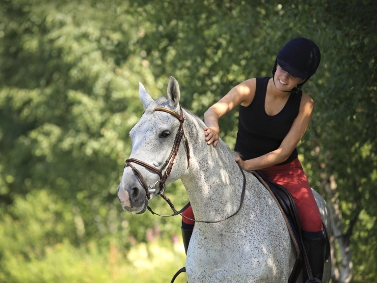 kobieta jadąca na koniu